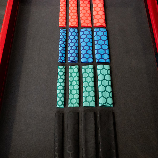 Four colours of the Olsa Tools heat shrink handle in green, red, black, and blue