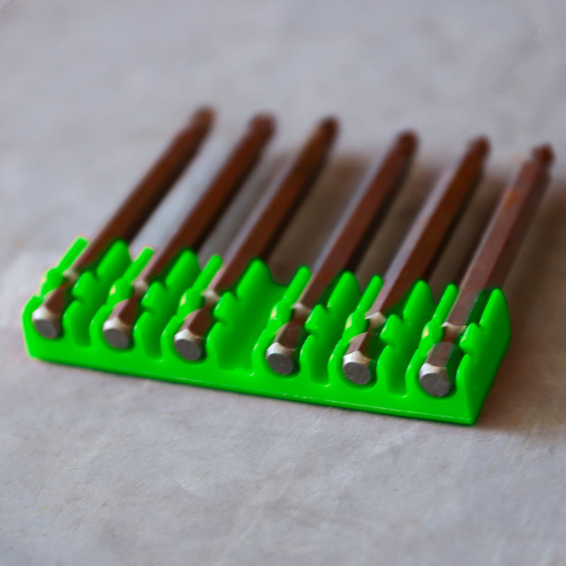 Horizontal hex bit holder holding long hex bits laying flat on the ground